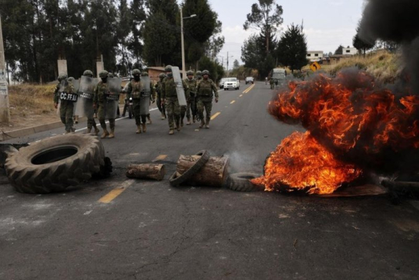 Members of the Ecuadorian Armed Forces remove debris after a protest on Pan-American Highway North in Tabacundo, Ecuador, on Tuesday. President Daniel Noboa said he would rather die than back down on his decision to eliminate diesel subsidies. Photo by Jose Jacome/EPA