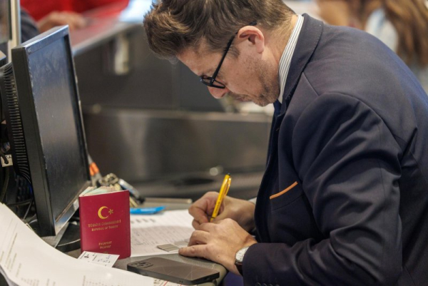 An airport worker seen Monday manually writing a bording pass in Brussels, Belgium after Saturday's cyber-attack left many European airports in virtual darkness. On Wednesday,s London's Heathrow said it was 