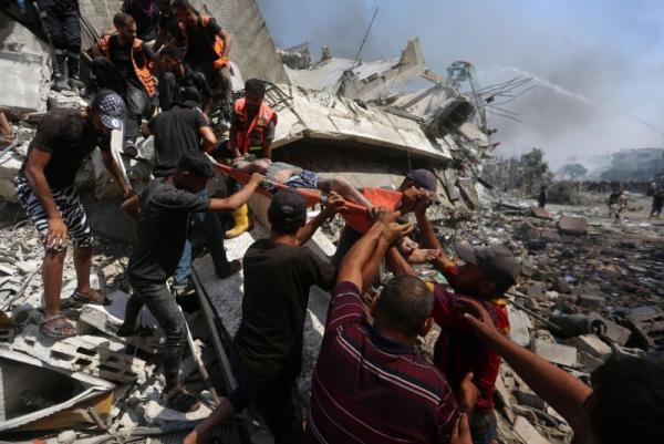 Members of the Palestinian rescue services carry a wounded person from a residential building struck by Israeli shelling during a large-scale Israeli military operation in Gaza City on Tuesday. Photo by Omar Ishtiwi/UPI