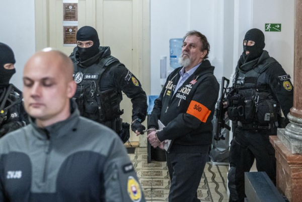 Juraj Cintula (C) was escorted Monday by police for the main trial over last year's assassination attempt of Slovakian Prime Minister Robert Fico at the Specialized Criminal Court in Banska Bystrica, Slovakia. Photo Provided by Jakub Gavlak/EPA